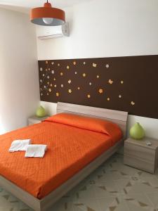 una camera da letto con un letto con lenzuola arancioni e farfalle sul muro di RosyMario a Castellammare del Golfo