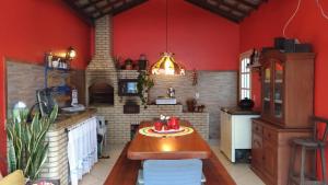 eine Küche mit roten Wänden und einem Tisch in einem Zimmer in der Unterkunft Casa na Praia do Foguete in Cabo Frio