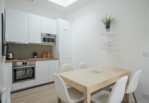 a kitchen with a wooden table and white cabinets at Le Scandinave, F3 avec terrasse, Villa Saint Charles in Paris