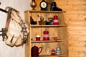 a wooden shelf with tea pots and a clock at Fleur des Neiges in Morzine