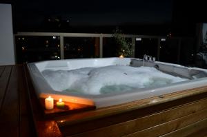 a large bath tub with a lit candle in it at XV Apartamentos in La Plata