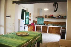 une cuisine avec une table et un tissu de table vert dans l'établissement Dimora di Campagna con vista mare, à Menfi