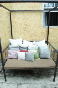 金斯敦的住宿－One32 Guesthouse Red Velvet，一张长凳上摆着一大堆枕头