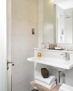 a white bathroom with a sink and a mirror at Mespil Hotel in Dublin