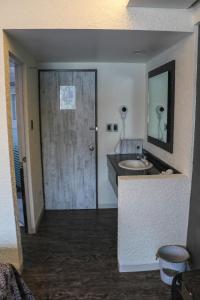 a bathroom with a sink and a door with a mirror at Hotel La Luna in Mexico City