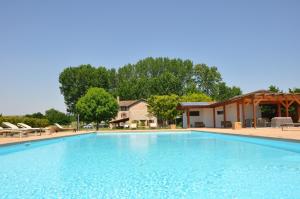 a large blue swimming pool in front of a house at La Casa Gioconda in San Michele al Tagliamento +2 photos