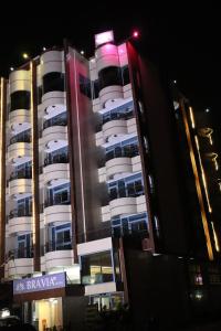 洛美Bravia Eco Hotel Lome的一座白色的大楼，前面有一块招牌
