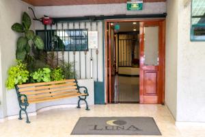 un banco de madera sentado frente a un edificio en Hotel La Luna, en Ciudad de México