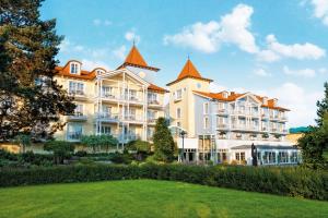 a large white building with orange roofs at Hotel Kleine Strandburg - Adults Only in Zinnowitz