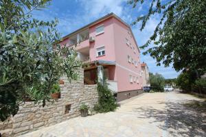 a pink building with a stone wall at Apartments Ulika in Rovinj