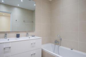 a bathroom with a tub and a sink and a mirror at L'Industriel, loft de 2 chambres, Villa Saint Charles in Paris