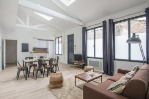 a living room with a couch and a table at L'Industriel, loft de 2 chambres, Villa Saint Charles in Paris