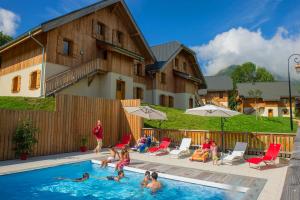 a group of people playing in a swimming pool at Goélia Les Chalets de Belledonne in Saint-Colomban-des-Villards +16 photos
