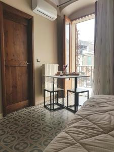 a bedroom with a bed and a table and a balcony at Nonna Ninetta in Melfi