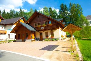 a house with a large driveway in front of it at Pension Sima in Harrachov