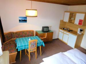 a small room with a table and a small kitchen at Appartement Vorreiter in Uttendorf