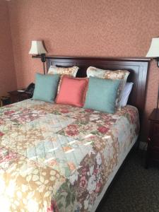 a bedroom with a large bed with colorful pillows at Hotel Mac in Richmond