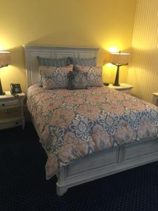 a bed in a bedroom with two lamps and two tables at Hotel Mac in Richmond