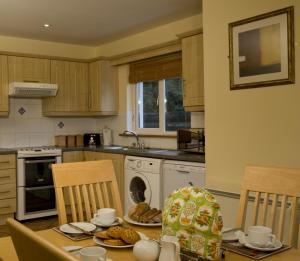 una cocina con mesa y sillas con comida. en Forest Haven Holiday Homes, en Dunmore East