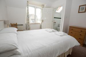 a bedroom with a large white bed with a window at Moore Bay Holiday Homes in Kilkee