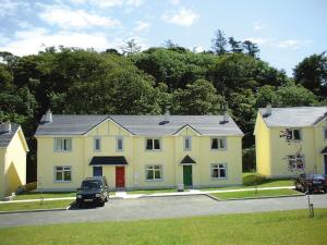 a yellow house with a car parked in front of it at Forest Haven Holiday Homes in Dunmore East