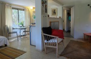 a living room with a chair and a kitchen at Natural Reserve Apartment in Zikhron Ya'akov