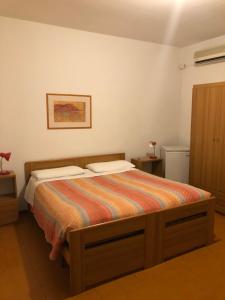 a bedroom with a bed with a striped blanket at Al Pontesel in Garda