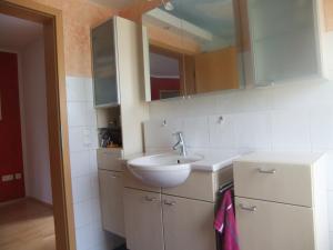 ein weißes Badezimmer mit Waschbecken und Spiegel in der Unterkunft Siggis Home in Wilhermsdorf + 2 Fotos