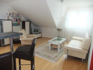 sala de estar con muebles blancos y mesa en Siggis Home, en Wilhermsdorf