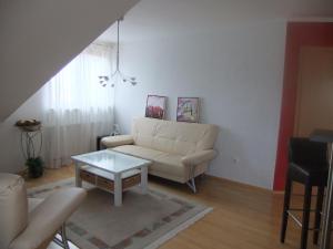 ein Wohnzimmer mit einer weißen Couch und einem Tisch in der Unterkunft Siggis Home in Wilhermsdorf