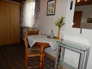 ein kleiner Tisch mit einer Blumenvase darauf in der Unterkunft Pension Ute in Zeulenroda