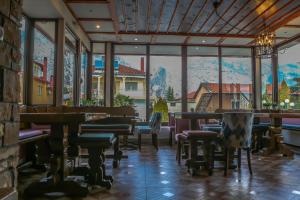 een restaurant met tafels en stoelen en een groot raam bij Kallinikos Guesthouse in Kato Loutraki