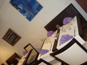 una mesa con copas de vino y servilletas moradas. en Hôtel restaurant HENRY en Puy-lʼÉvêque