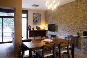 a dining room with a wooden table and chairs at Gallaret in Sant Juliá de Vilatorta