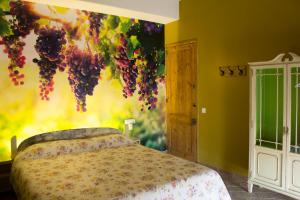 a bedroom with a bed with grapes on the wall at Gallaret in Sant Juliá de Vilatorta