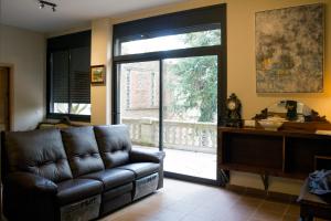 a living room with a leather couch and a sliding glass door at Gallaret in Sant Juliá de Vilatorta