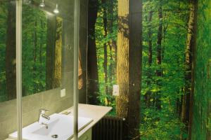 a bathroom with a sink and a mirror and trees at Gallaret in Sant Juliá de Vilatorta