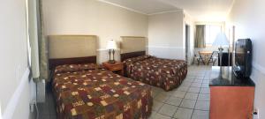 a hotel room with two beds and a table at Four Winds Motel in Seaside Heights