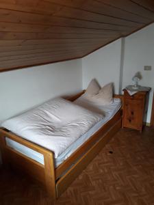 ein kleines Bett in einem Zimmer mit Holzdecke in der Unterkunft Al Becalen in Livinallongo del Col di Lana