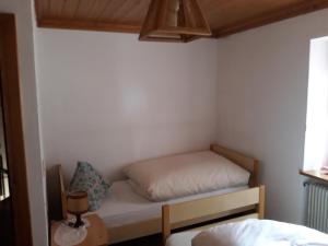 ein kleines Zimmer mit einem Bett und einem Fenster in der Unterkunft Al Becalen in Livinallongo del Col di Lana