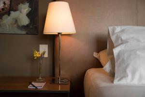 una lámpara sentada en una mesa junto a una cama en Esplendor by Wyndham El Calafate en El Calafate