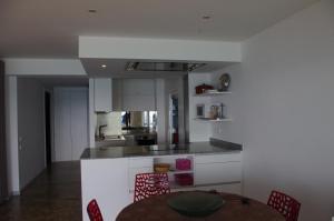 a kitchen with a table and a kitchen with white cabinets at Eden Playa Standing in Sant Antoni de Calonge