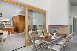 a kitchen and dining room with a wooden table and chairs at Casa Vidmar in Klimno