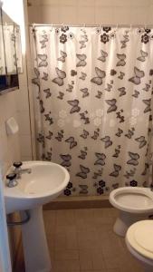 a bathroom with a sink, toilet and shower curtain at Hotel Bonino in Villa Mercedes