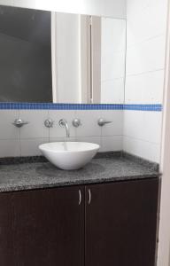a bathroom counter with a white sink and a mirror at Espacio C Ambrosio Olmos in Cordoba