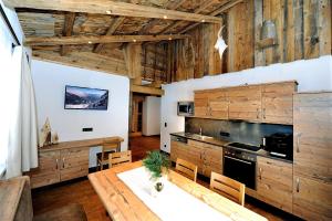 ザールバッハ・ヒンターグレムにあるAppartement Berghofのキッチン(木製キャビネット、テーブル、椅子付)