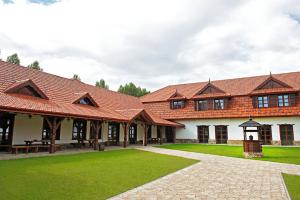 un grande edificio con un prato verde davanti di Hotel Chutor Kozacki a Łukowe