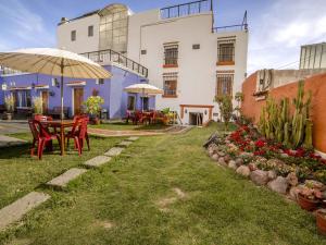 
a patio area with chairs, tables and umbrellas at Las Torres de Ugarte in Arequipa

