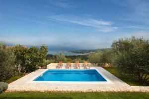 a swimming pool with two chairs and a swimming pool at Villa Maria in Sužan