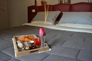 uma bandeja de comida e flores numa cama em Valuan Luxury Home em Palermo